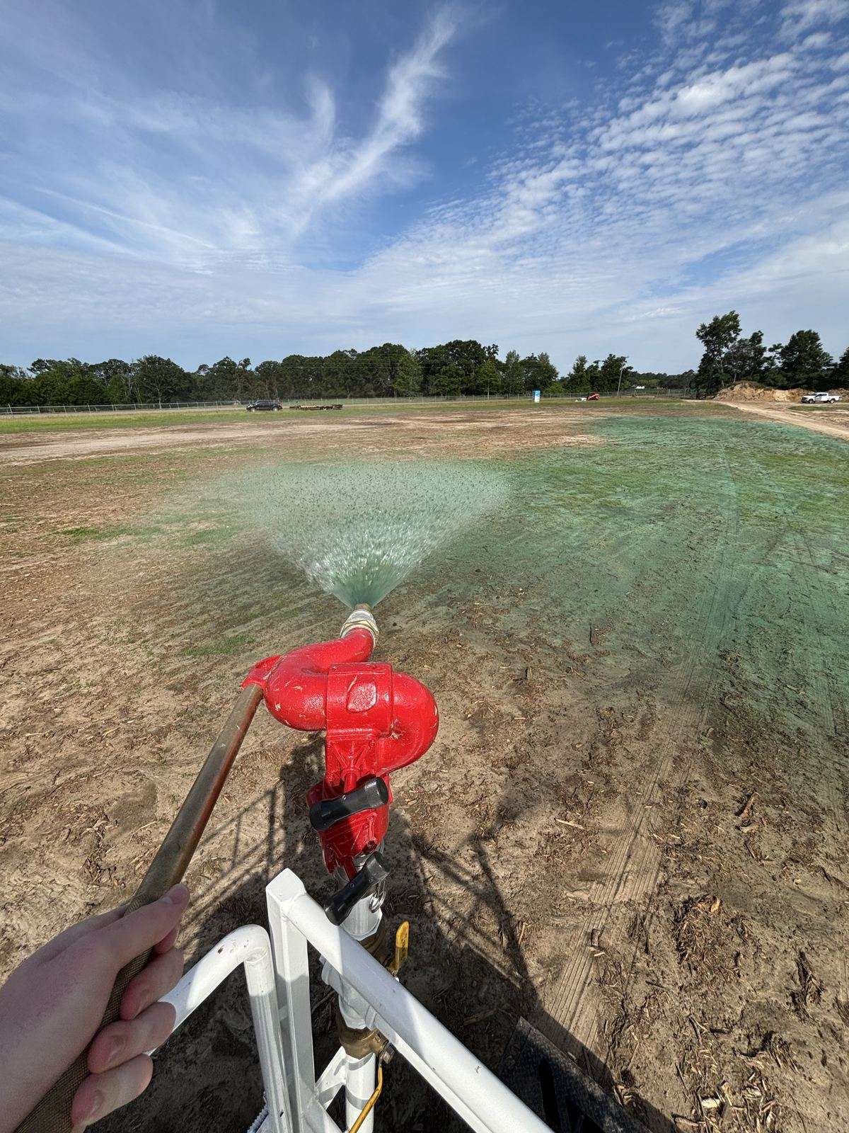 Wide hydromulch spray from the TurfMaker 2200 cannon over bare soil