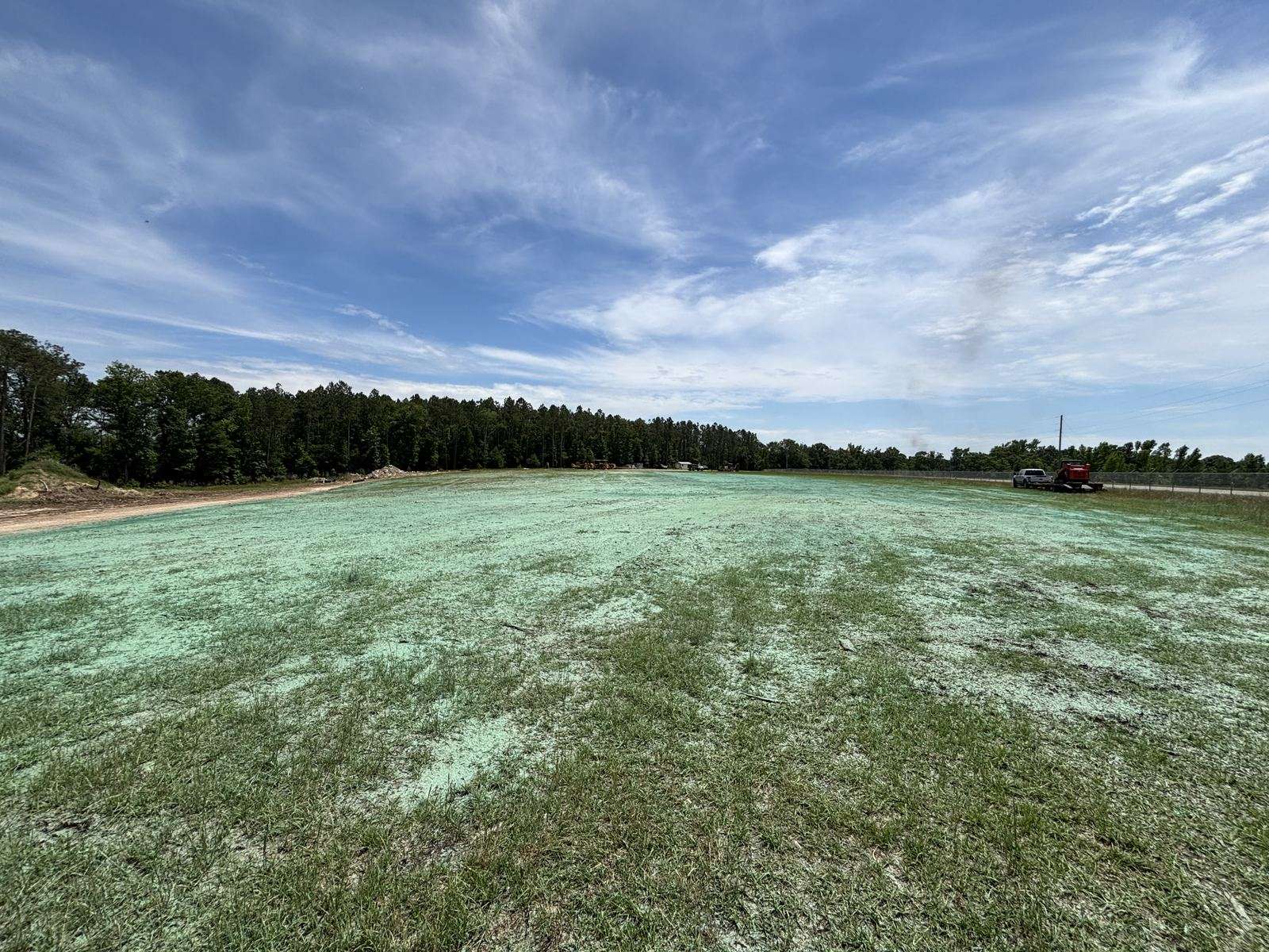 Large open field covered in green hydromulch sprayed by the TurfMaker 2200